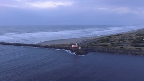 Coquille-River-lighthouse-drone-footage-taken-during-sunset,-where-Pacific-Ocean-meets-the-Oregon-coast