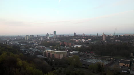 Aerial-Flyover-Reveal-of-Leeds-Cityscape-at-Dawn-on-Sunny-Spring-Day