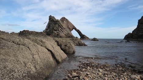 Bow-Fiddle-Rock-from-the-shoreline-on-a-sunny-calm-day-with-rocks