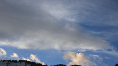 Timelapse-showing-clouds-moving-across-an-evening-sky-with-a-silhouette-of-a-mountain-ridge