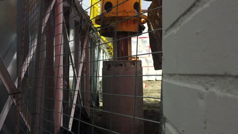 Wide-shot-of-drill-bit-pipe-from-a-hydraulic-rotary-drilling-rig-being-lowered-into-place,-then-rotation-of-drill-column
