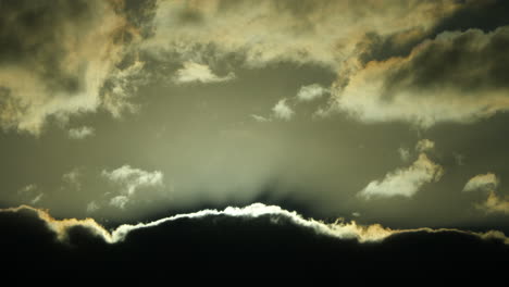 Himmel-Mit-Dunklen-Regenwolken-Mit-Silbernen-Und-Goldenen-Umrissen,-Die-Die-Sonne-Verdecken-–-Langsame-Hypnotische-Bewegung