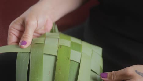 Closeup-in-slow-motion-of-a-woman-weaving-plants-to-make-a-basket-in-a-traditional-maori-way