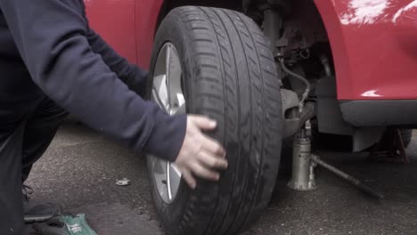 Installing-the-front-tire-on-a-car-and-hand-tightening-the-lug-nuts