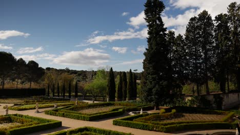 Static-shot-o-a-baroque-garden-with-trees-a-blue-sky-with-clouds-moving-to-the-left