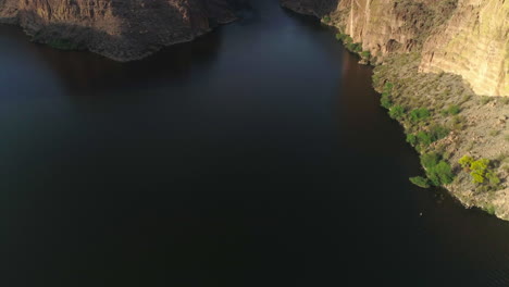 AERIAL---Drone-Tilt-Up-to-Reveal-Waterway-Between-Mountains