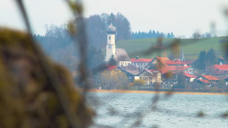 Closeup-shot-of-Gmund-near-the-Tegernsee-lake-seen-from-the-other-side-through-branches