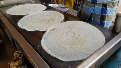 A-man-making-dosa-on-a-huge-stone-plate