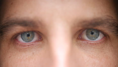 Close-up-of-a-young-man's-light-blue-eyes,-staring-at-the-camera-without-blinking