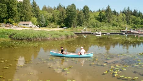 two-men-canoeing-on-a-lake-with-lilies