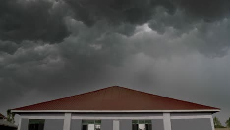 Ein-Blitzschlag-über-Einem-Haus,-Während-Dunkle,-Bedrohliche-Gewitterwolken-Aufziehen