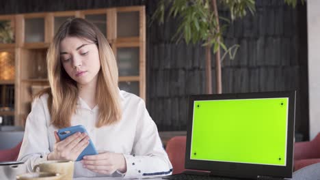 Eine-Charmante-Junge-Frau-Sitzt-Neben-Dem-Laptop-Und-Zeigt-Einen-Grünen-Bildschirm