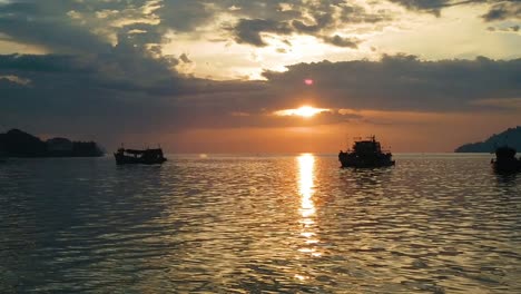 Slow-motion-shot-of-the-sun-setting-over-the-boats-in-a-bay-in-Borneo,-Malaysia
