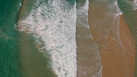 Luftaufnahme-Von-Wellen,-Die-über-Einer-Flachen-Sandbank-In-Der-Nähe-Eines-Beliebten-Strandes-Brechen