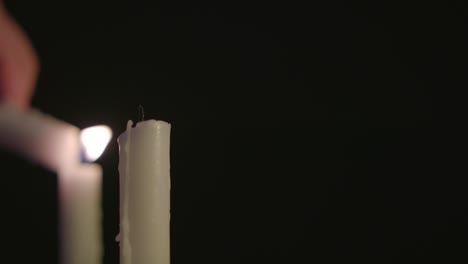One-white-candle-lighting-two-white-Candles