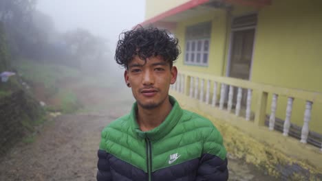 Porträt-Eines-Asiatischen-Mannes-Mit-Lächelndem-Kopf-Und-Lockigem-Haar,-Der-An-Einem-Nebligen-Wintermorgen-In-Die-Kamera-Blickt