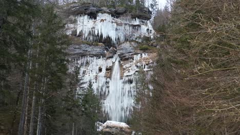 Stunning-frozen-waterfall-icicles-on-rocky-mountain-cliff-on-a-winter-day