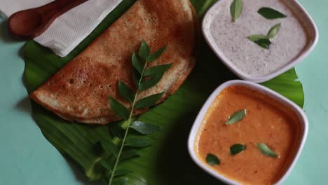 Rotating-masala-dosa,South-Indian-meal-Set-Dosa-,sambhar-and-coconut-chutney-on-green-background