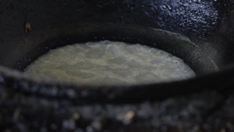 closeup-of-boiling-fat-in-a-black-pot