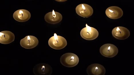 Candles-Slowmotion---Small-Candles-Burning-On-Black-Background
