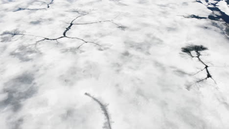 Luftaufnahme-Des-Zugefrorenen-Sees-Von-Oben-Nach-Unten,-Kippt-Nach-Oben-Zur-Verschneiten-Berglandschaft