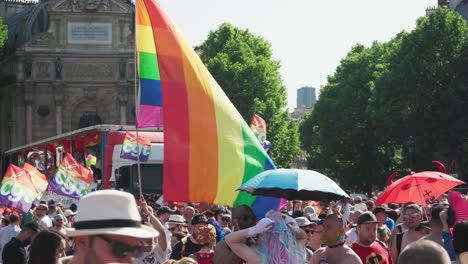 Der-Gay-Pride-Marsch-Geht-Mit-Einer-Person-Vorbei,-Die-Eine-Regenbogenfahne-Hält