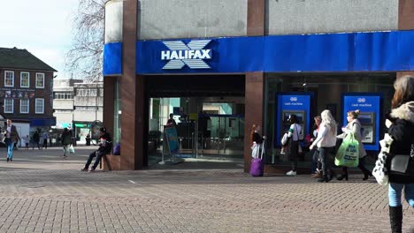 People-using-a-Halifax-ATM,-cash-machine-to-withdraw-money,-deposit-cash-or-pay-some-bills-on-the-high-street-in-the-city-centre