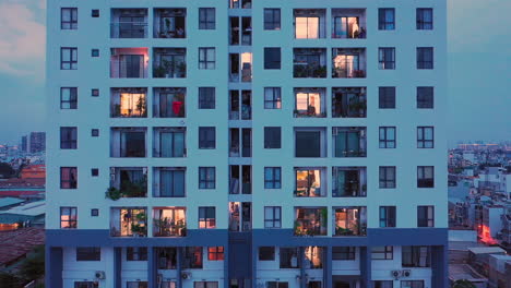 Wide-Tracking-shot-of-outside-of-25-Level-Modern-apartment-building-having-a-view-into-peoples-lives