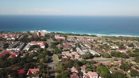 Luftaufnahmen,-Die-Von-Einer-Drohne-Von-Scottburgh-Beach-Und-Landgrasfeldern-Mit-Wohnhäusern-Mit-Blick-Auf-Das-Meer-In-Kwa-Zulu,-Natal,-Südafrika,-Gefilmt-Wurden