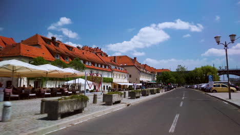 Driving-through-Lent,-the-popular-waterfront-of-Maribor,-Slovenia,-with-caffees-and-bars