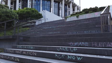 Inclinación-Lenta-Hacia-Arriba-Que-Revela-Graffiti-De-Acción-Contra-El-Cambio-Climático-Y-Edificio-Del-Gobierno-De-Nueva-Zelanda
