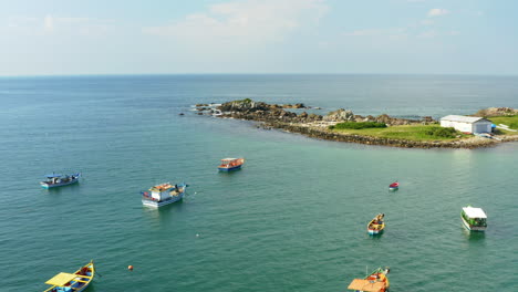Aerial-view-wooden-fisherboats-and-fantastic-rocky-coast,-Praia-Armacao,-Florianopolis,-Santa-Catarina,-Brazil
