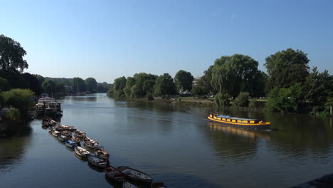 Shot-of-the-river-thames-from-Richmond-with-boats-standing-still-and-a-canal-boat-moving