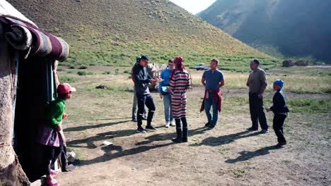 Gente-Comunicándose-Con-Nómadas-Cerca-De-Un-Campamento-De-Yurtas-En-Las-Montañas-De-Kirguistán-Como-Parte-De-La-Cultura-Local