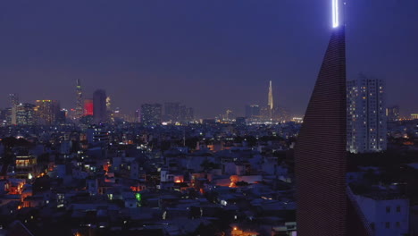 4k-drone-footage-crane-shot-of-church-spire-spire-at-night-climbing-to-reveal-neon-christian-cross-and-the-lights-of-the-urban-landscape-and-city-skyline-placing-christianity-at-its-center
