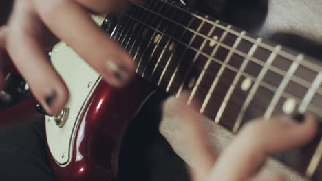 Hands-with-a-shabby-black-nail-polish-playing-the-guitar
