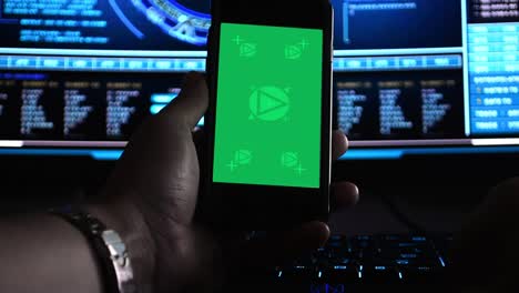 Hacker-using-a-smartphone-in-front-of-hi-tech-screens,-motion-tracked-for-easy-screen-replacement