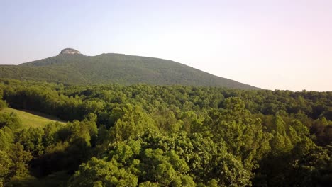 Aerial-of-Pilot-Mountain-in-background-as-drone-pushes-toward-the-summit-in-4K