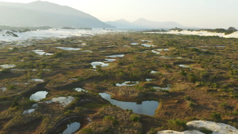 Aerial-cinematic-drone-view-lagoons-and-sand-dunes-at-Praia-Da-Joaquina,-Florianopolis-city,-Santa-Catarina,-Brazil