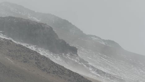 Volcanic-hillside-with-snow-at-altitude