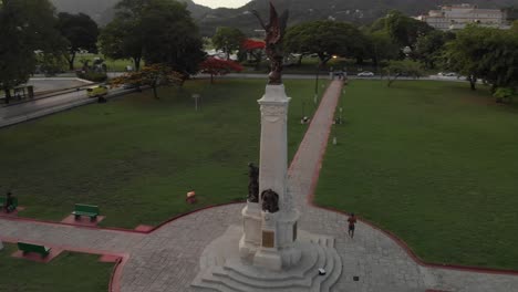 Epic-aerial-of-a-cenotaph-statue-in-memorial-park-with-a-performing-arts-center-in-the-background