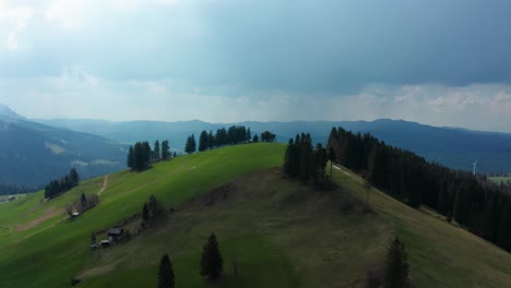 Luftaufnahme-Eines-Wunderschönen-Grünen-Grashügels-Im-Entlebuch,-Schweiz,-Atemberaubende-Berglandschaft,-Frühlingsfarben,-Schneeberge