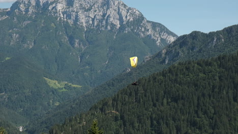 Flying-in-the-mountains,-paraglider-in-Alpine-landscape,-freedom-and-adventure-concept,-adrenaline-sport,-Logar-valley-in-Slovenia