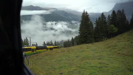 Slow-motion:-Swiss-train-climbing-steep-mountainside-above-the-clouds