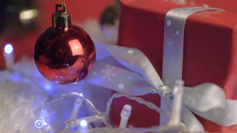 Weihnachtsgeschenk-Gebunden-Mit-Bandkugeln-Und-Blinkenden-Lichtern-Im-Hintergrund