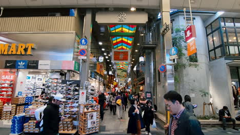 A-dolly-zoom-out-video-of-a-famous-tourist-area-at-Kyoto,-Japan-with-tourists-and-Japanese-shopping-around-the-Nishiki-market-for-sale