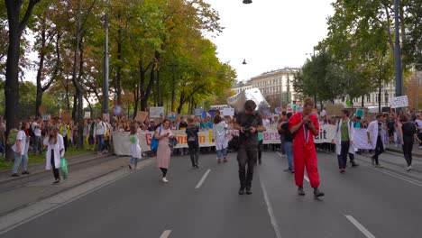 Wide-frontal-view-of-people-walking-through-wide-street-in-Vienna,-Austria-during-fridays-for-future-climate-change-protests