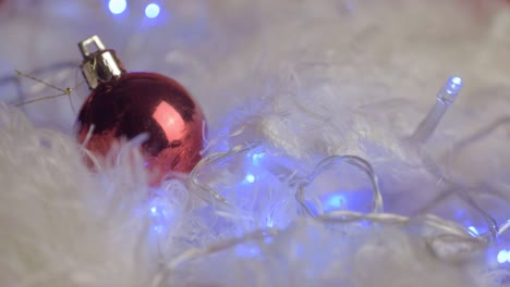 Christmas-red-baubles-with-Christmas-lights-on-white-fur-background