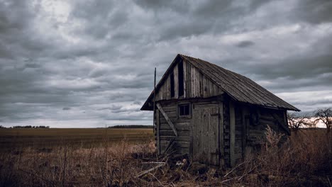 Old-abandoned-wooden-barn-in-the-fields-and-cloudy-sky-movement-time-lapse-video