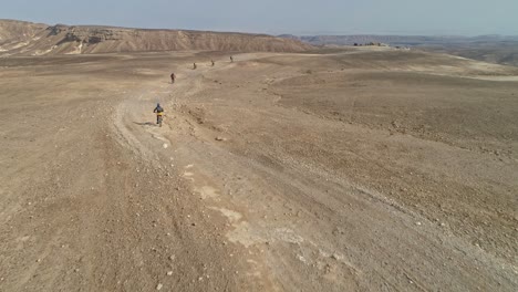 Luftaufnahmen-Einer-Gruppe-Von-Fahrradfahrern,-Die-Auf-Radwegen-In-Der-Wüste-Unterwegs-Sind